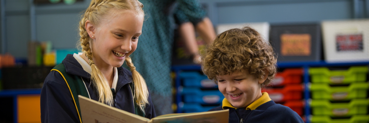 Two students enjoying a book together.