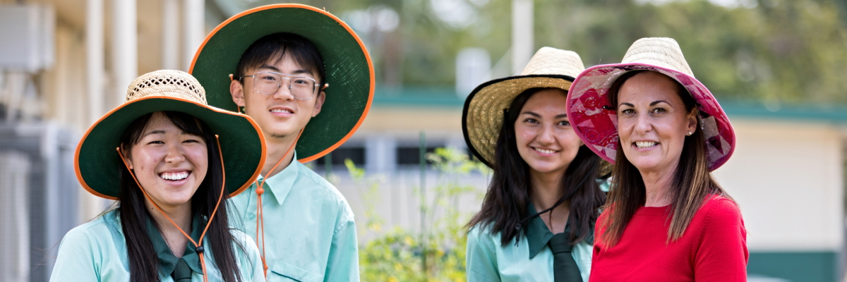 Students and their teacher out in the sun wearing hats