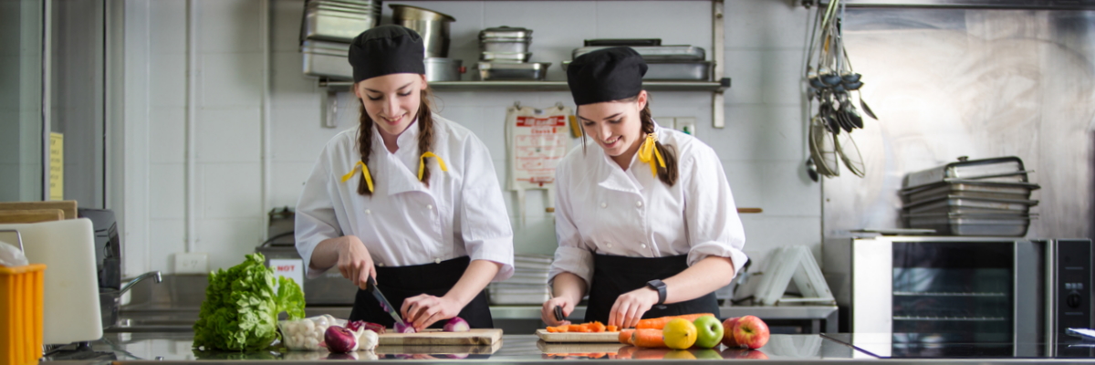 Two students cutting vegetables