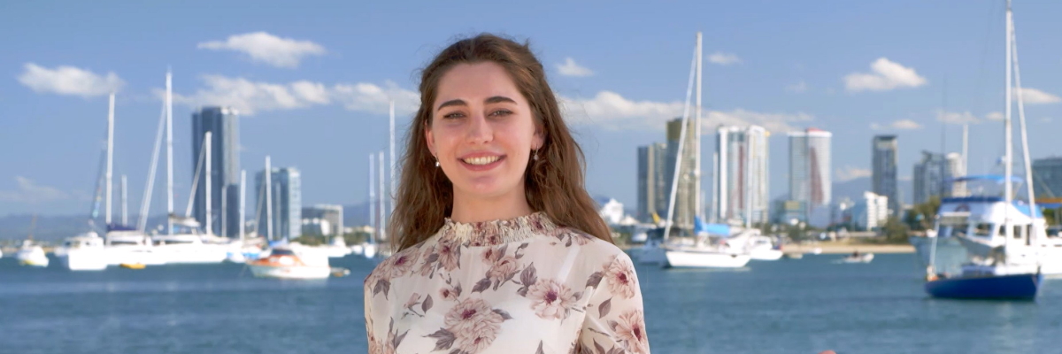 An Alumna in front of boats in the water